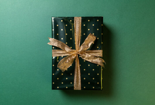 one Christmas wrapped gift on green background