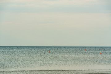 calm water surface on which orange buoys fly