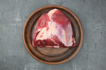 fresh and raw piece of beef meat prepared for grilling or barbecue. delicious whole piece of red meat on a clay plate.