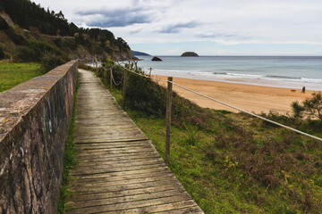 Fototapeta na wymiar Wooden path next to the Laga's beach in Basque Country during a cloudy day