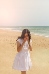Fototapeta na wymiar Woman on the beach hiding her face
