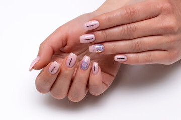 Gently pink manicure with sparkles and black stripes on long nails bolero form on a white background close up - obrazy, fototapety, plakaty