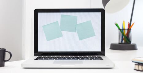 Fototapeta premium Notes sticked to laptop screen at home office.
