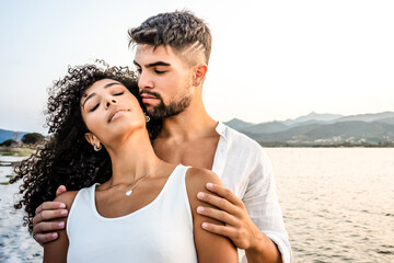 Heterosexual mixed race couple in romance scene at sunset with vintage photo effect filter -...