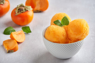 Persimmon ice cream , sorbet and mint leaves. Closeup - obrazy, fototapety, plakaty