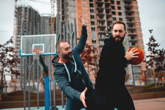 Friends playing basketball on the court in the city