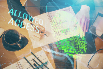 Blue fingerprint hologram over woman's hands taking notes background. Concept of protection. Double exposure