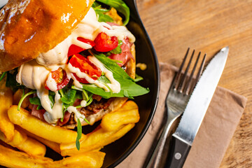 Panino da pub con hamburger, prosciutto crudo, pomodori, mozzarella, rucola e maionese