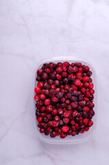 Frozen cranberries in a plastic container