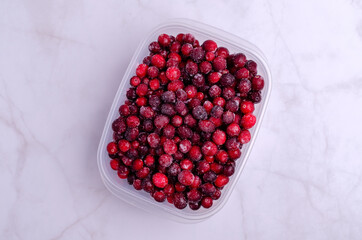 Frozen cranberries in a plastic container