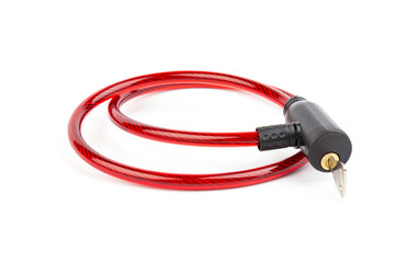 Flexible red bicycle cable with key on white background.  Security and safety concept.