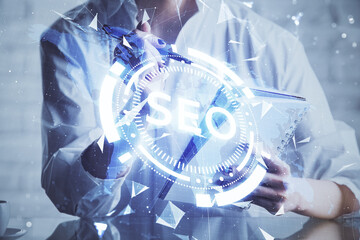 Multi exposure of woman's hands making notes with SEO icon. Concept of Search engine optimization