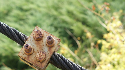 Close-up of iron cable with details of old river bridge