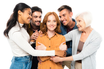 Multicultural friends embracing smiling woman isolated on white