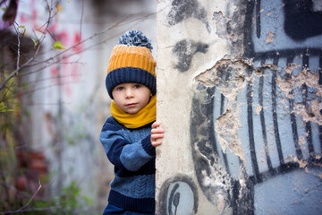 Child, posing in an old ruin building, sprayed with graffiti
