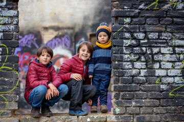 Obraz na płótnie Canvas Children, posing in an old ruin building, sprayed with graffiti