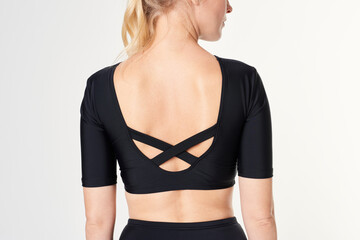 Fototapeta premium Rear view of a blonde woman in a black long sleeved swimwear mockup