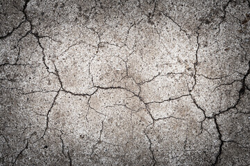 Background with a surface covered with cracks.
Texture with cracks of old paint on the pavement. 