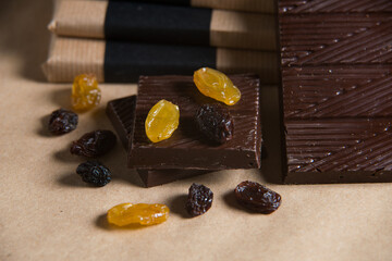 Homemade chocolate bar with raisins on craft paper background