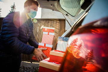 Fototapeta na wymiar man packing Christmas gift boxes in car