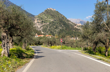 The road in a village Mystras (Greece, Peloponnese) and view of the fortress on the mountain