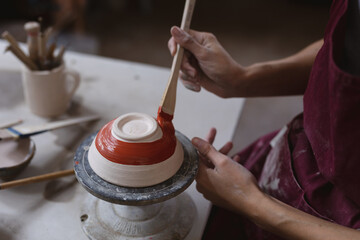 Caucasian female potter in face mask working in pottery studio