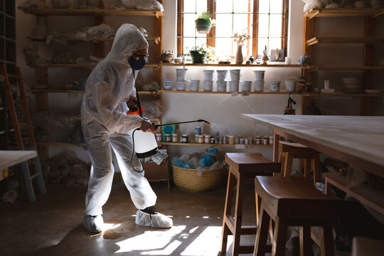 Caucasian male cleaner in protective clothes working in pottery studio