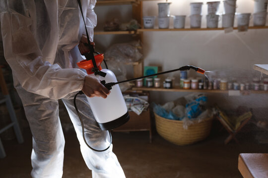 Caucasian male cleaner in protective clothes working in pottery studio