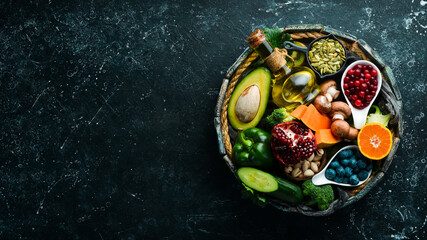 Set of fruits, vegetables, berries and nuts in a wooden box. Vegan food. Top view. Rustic style.