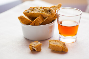 Italian Cantuccini almond cookies with glass of vin santo amaretto. Selective focus - shallow depth of field.