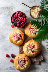 Homemade Sweet Yeast Buns filled with Berry and with crumble. Concrete bsckground.