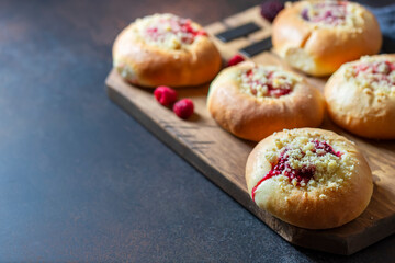 Homemade Sweet Yeast Buns filled with Berry and with crumble on a black background.