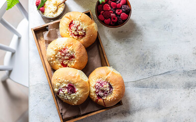 Homemade Sweet Yeast Buns filled with Berry and with crumble. Concrete bsckground.
