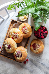 Obraz na płótnie Canvas Homemade Sweet Yeast Buns filled with Berry and with crumble. Concrete bsckground.