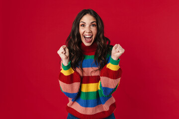 Excited beautiful brunette girl posing with clinched fists