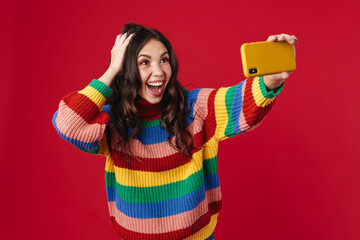 Happy beautiful girl taking selfie on cellphone and smiling