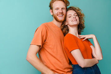 Fototapeta premium Young happy redhead couple smiling and hugging at camera