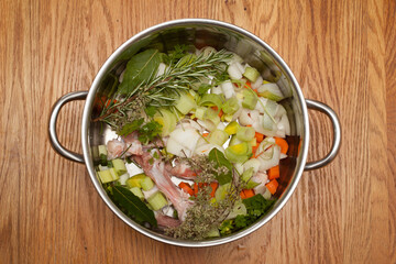 A pan full of chicken bones, vegetables and herbs ready to make a chicken stock