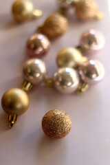 Christmas baubles in gold and pink tones. Selective focus, pink background.