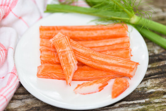 Crab sticks sliced on white plate and vegetable , Fresh crab sticks surimi ready to eat japanese food.