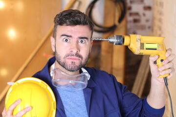 Stressed out construction worker holding drill 