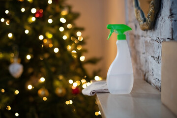 A bottle of detergent against the background of New Year's lights. General professional cleaning before Christmas. Spray disinfection