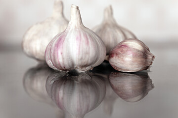 Obraz premium Garlic and garlic clove on the table with a reflection.