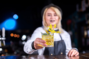 Girl bartender mixes a cocktail in the public house