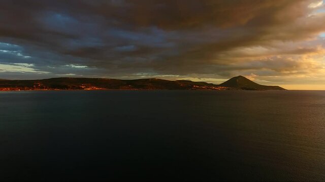 Aerial view of Pylos bay, Peloponnese, Greece, at golden dusk with clouds lit by the setting sun.
