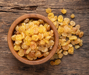 Raisins in a wooden bowl on a wooden