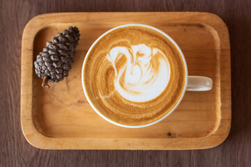 Cup of hot latte art coffee on wooden table