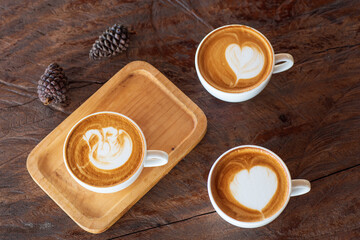 Cup of hot latte art coffee on wooden table