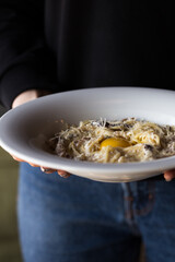 Pasta Carbonara. Spaghetti with bacon, egg, parsley and Parmesan cheese sauce in a white plate on a wooden table. traditional Mediterranean (Italian) dish. Selective focus