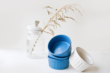 Set of ceramic dishes: small plates and glass jar on wooden background
